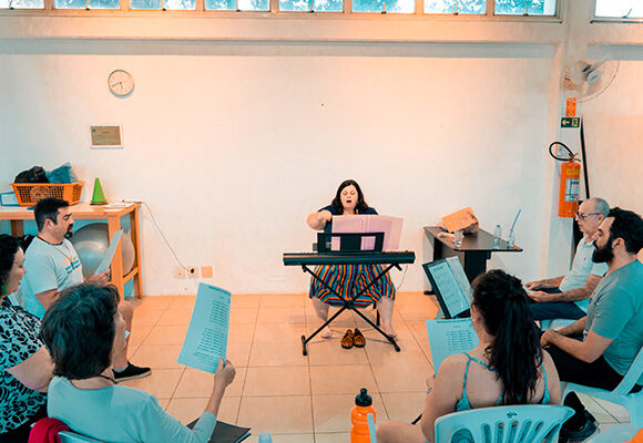 A professora Ciça Baradel com um teclado durante a aula de canto.