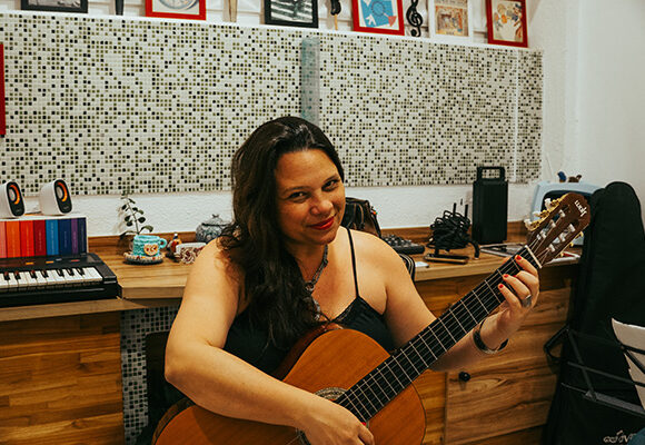 Professora Livia Canola tocando violão